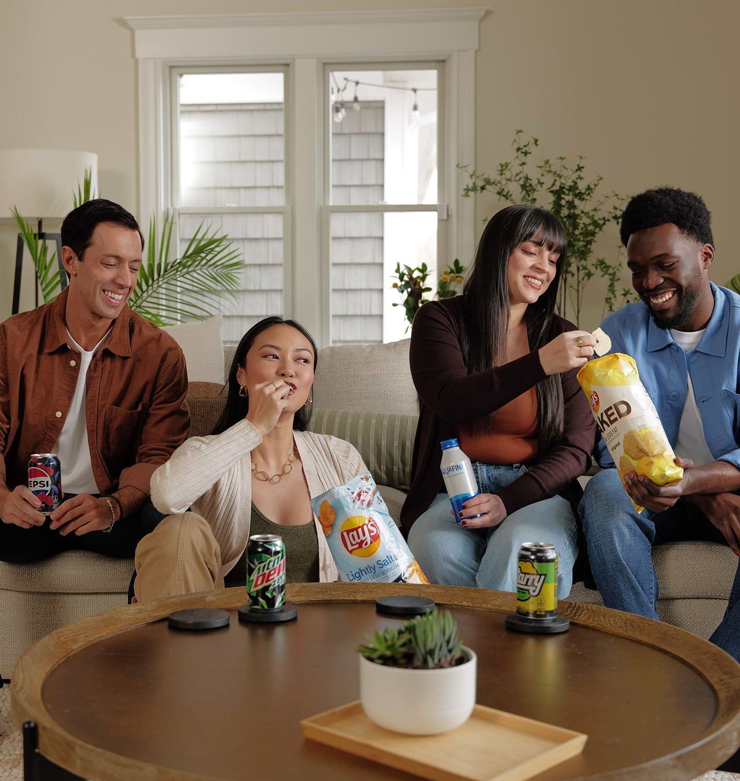 Personas reunidas disfrutando bebidas y botanas de PepsiCo