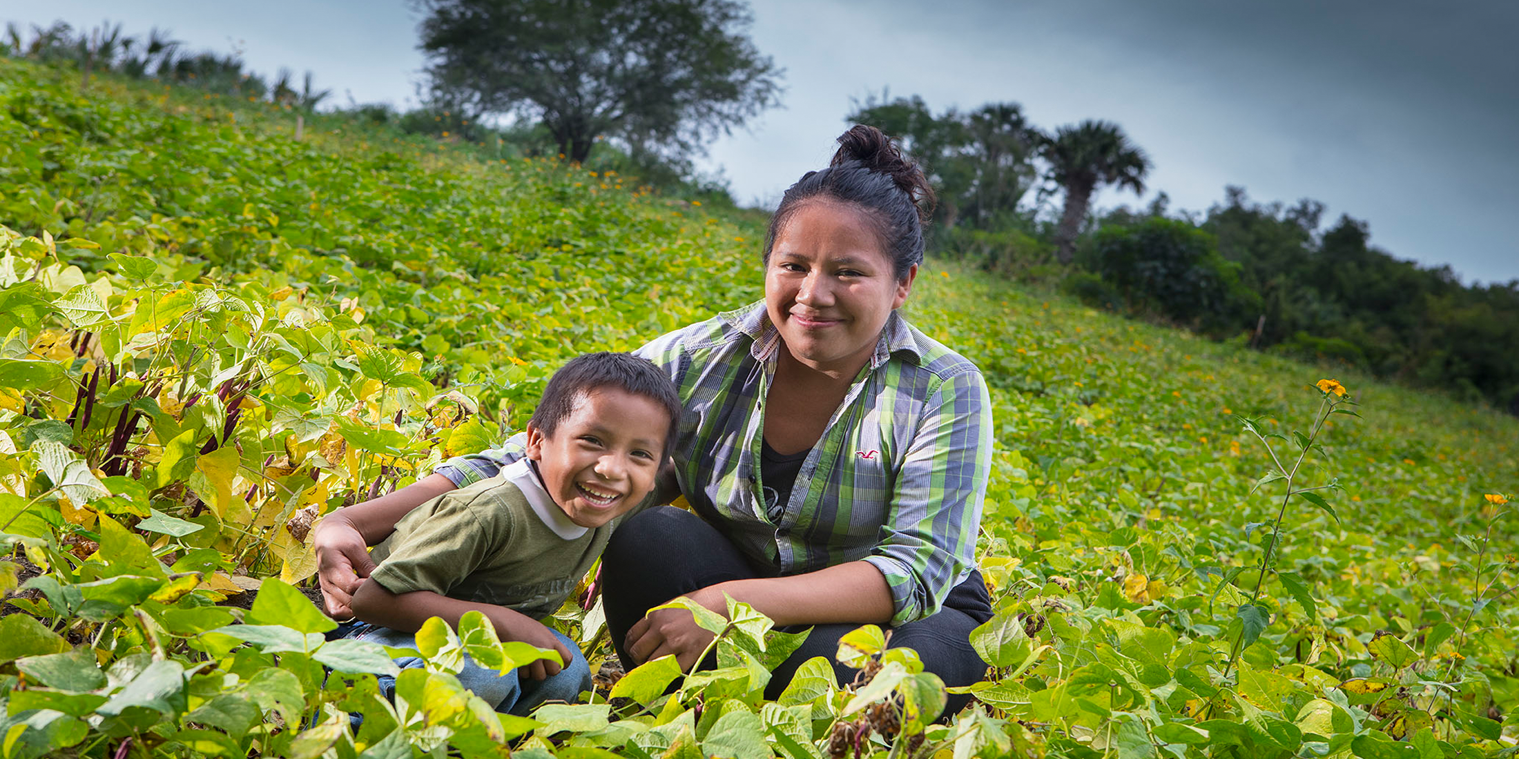 Mother and son sitting in a farming field